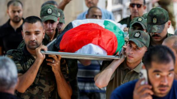 Members of Palestinian security forces carry the body of a Palestinian from Gaza killed in Jericho as Iran fired a salvo of ballistic missiles against Israel, during his funeral in Jericho, in the Israeli-occupied West Bank October 2, 2024. REUTERS/Mohammed Torokman