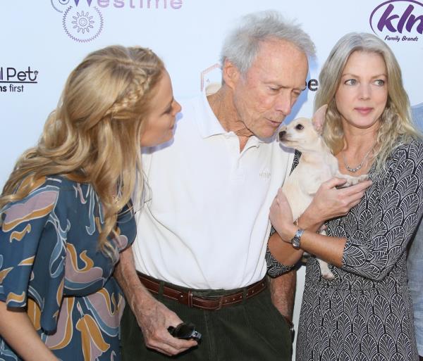 Director Clint Eastwood and actress Alison Eastwood holding wine glasses at the after party for the premiere of 'Gran Torino'