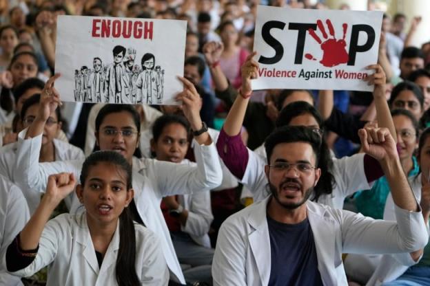 Doctors in India hold signs during a protest.